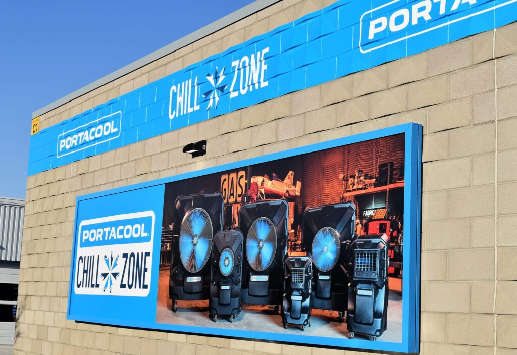 A building with "PORTACOOL Chill Zone" sign and large coolers against a beige exterior and clear blue sky.
