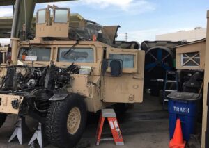 Portacool evaporative cooler behind a Humvee on a military base, cooling the mechanics.