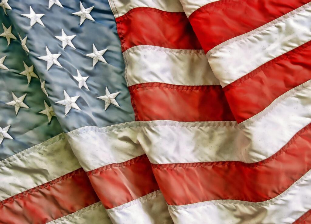Close-up of a crumpled American flag, highlighting the blue stars and red-white stripes, symbolizing Military Appreciation Month.