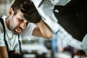 auto mechanic overheating in a hot garge