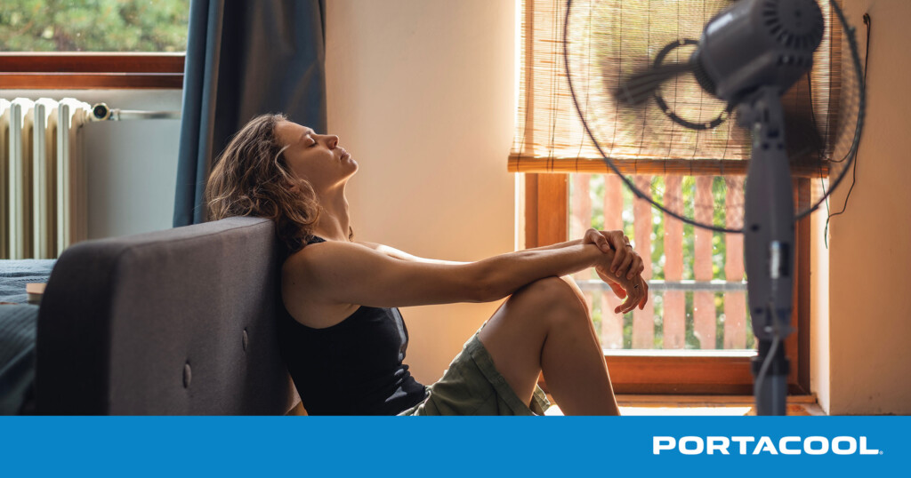 A woman tries to cool off in her home in front of a fan.