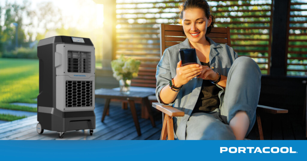 A woman lounges comfortably on her patio, with a Portacool evap cooler cooling the patio during the summer.