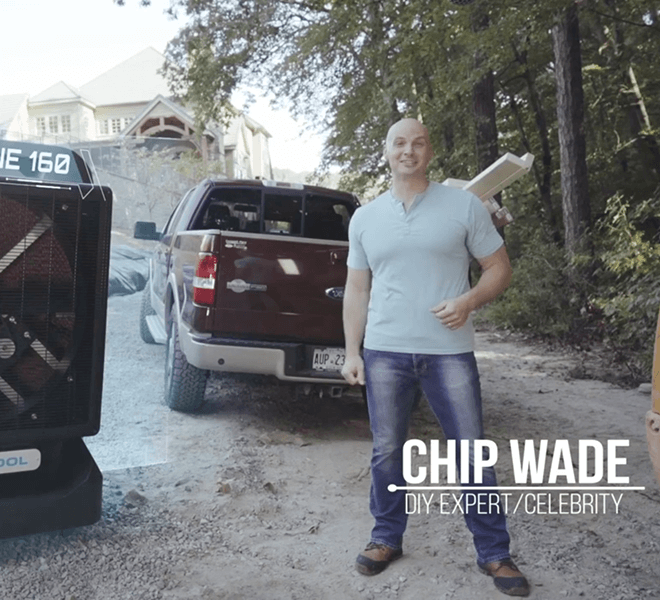 A person in a light blue shirt and jeans stands beside a red truck and Portacool, smiling. Background shows trees and a house. Text: "Chip Wade DIY Expert/Celebrity".
