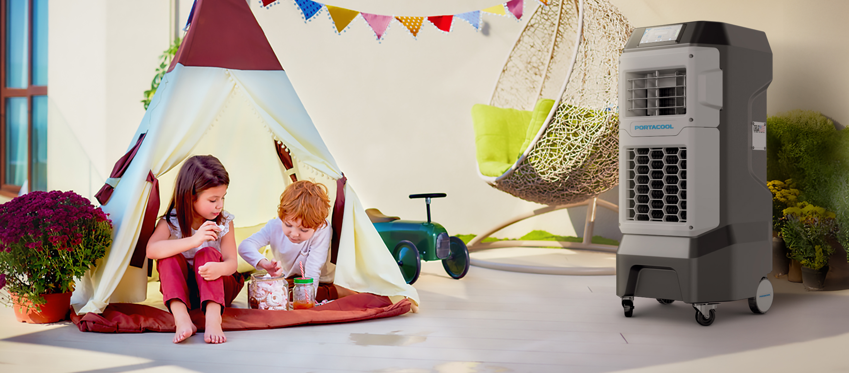 Two kids snack in a decorated tent on a patio, surrounded by plants. A hanging chair and toy car add to the cozy home ambiance.