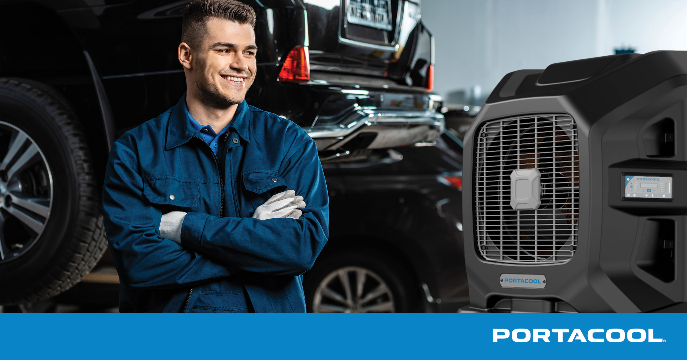 An automotive technician stands in an auto service shop with cars on lifts around him, and a Portacool evap cooler running in the background.