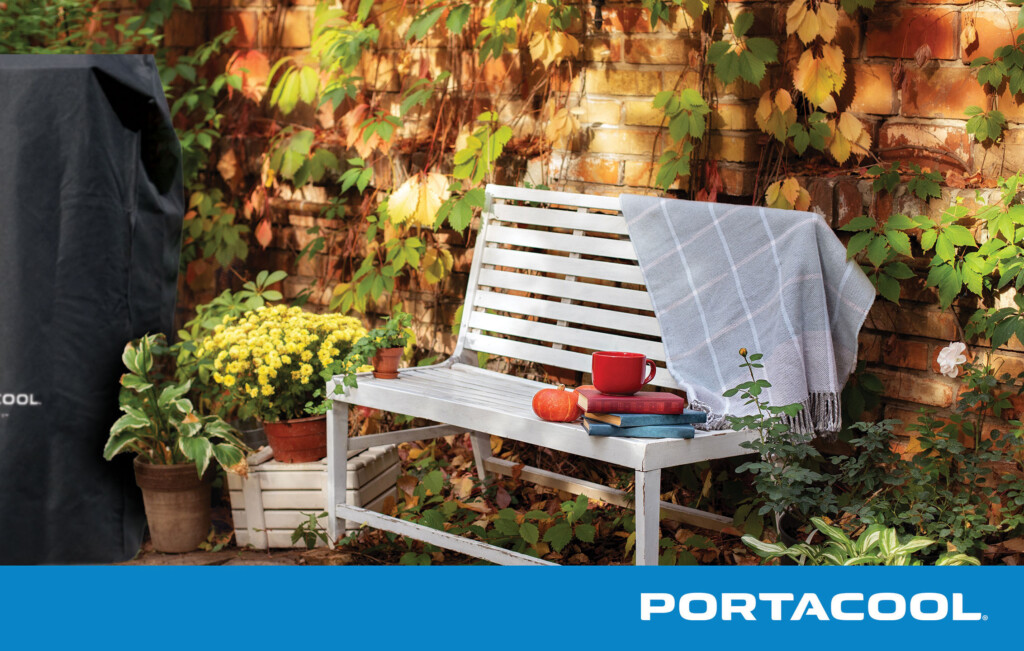 A back patio in the fall with books on a bench, and a Portacool portable evap cooler under a protective cover after being prepared for seasonal storage.