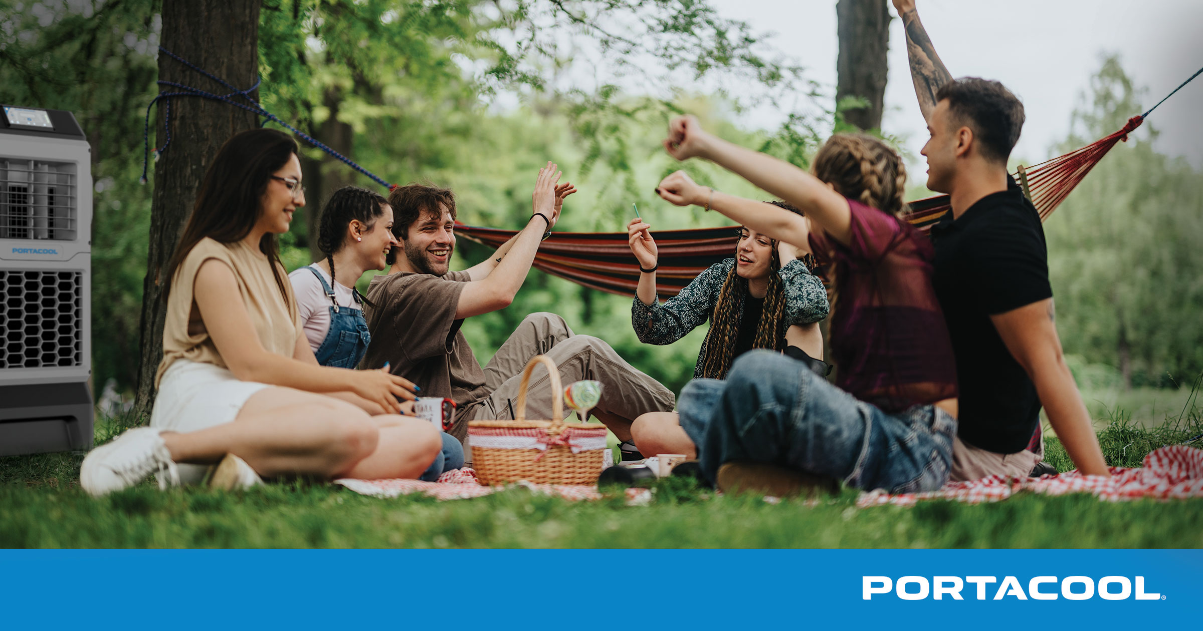 Friends gather for a picnic, kept cool and comfortable by a Portacool portable evaporative cooler.