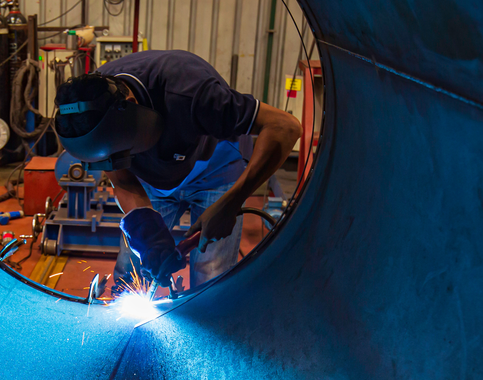 A welder working in a hot, confined space, being kept cool by a Portacool APEX 700 upgraded with a VORTEX precision cooling kit.